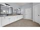 Spacious bathroom featuring granite countertops, dual sinks, modern fixtures, and stylish mirrors at 511 Wagon Hill Ln, Sugar Hill, GA 30518