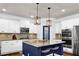 Kitchen featuring white cabinets, stainless appliances, and island with pendant lighting at 511 Wagon Hill Ln, Sugar Hill, GA 30518