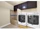 Functional laundry room featuring modern washing machines, cabinets, and a tiled shower area at 511 Wagon Hill Ln, Sugar Hill, GA 30518