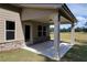 Covered back porch with brick accents and a view of the lush green lawn at 3828 Southfield Ct, Loganville, GA 30052