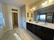 Bathroom showcasing double vanity with dark cabinetry and tiled floor, with a separate shower at 3828 Southfield Ct, Loganville, GA 30052