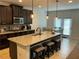 Modern kitchen featuring granite countertops, an island with bar stools, stainless appliances, and a dining area at 140 Craines Vw, Covington, GA 30014