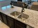 Modern kitchen island features a double sink, granite countertops, and sleek dark cabinets at 140 Craines Vw, Covington, GA 30014