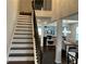 Bright foyer featuring hardwood stairs, dark railing, and natural light, leading into the dining and living spaces at 140 Craines Vw, Covington, GA 30014