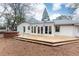 Exterior view of home with large deck and hot tub overlooking private backyard with mature trees and blue skies at 2466 Sharondale Ne Dr, Atlanta, GA 30305