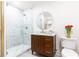 Bathroom featuring stone tiled shower with glass door, wood vanity and round mirror at 2466 Sharondale Ne Dr, Atlanta, GA 30305