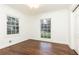 Bedroom featuring white trim, walls and door with wood flooring and two windows at 2466 Sharondale Ne Dr, Atlanta, GA 30305