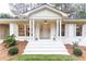 Inviting front porch with white columns, decorative statues, and lush landscaping at 2466 Sharondale Ne Dr, Atlanta, GA 30305