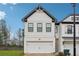 Modern two-story home with white siding, black trim, and a two-car garage at 43 N Auburn Landing Pl, Auburn, GA 30011