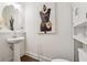 Stylish powder room with pedestal sink and chic Chanel-inspired artwork at 43 N Auburn Landing Pl, Auburn, GA 30011