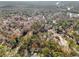 An aerial view of a wooded neighborhood with mature trees and manicured lawns at 9480 Hillside Dr, Roswell, GA 30076