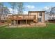 Exterior view of the backyard, highlighting the deck, patio area, and manicured lawn at 9480 Hillside Dr, Roswell, GA 30076