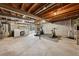 Unfinished basement with concrete floors and exposed beams, featuring laundry area and exercise equipment at 9480 Hillside Dr, Roswell, GA 30076