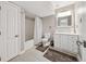 Well-lit bathroom with a shower-tub combo, white vanity, and neutral-colored tile flooring at 9480 Hillside Dr, Roswell, GA 30076