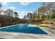 Large community pool covered for the off-season is surrounded by lounge chairs and landscaping at 9480 Hillside Dr, Roswell, GA 30076