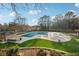 Covered community pool surrounded by lawn and landscaping including mature trees on a sunny day at 9480 Hillside Dr, Roswell, GA 30076