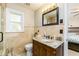 Bright bathroom featuring a toilet, vanity, window, and a view to a bedroom at 271 Double Gate Ct, Sugar Hill, GA 30518