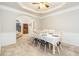 Formal dining room with large table, neutral walls, crown molding, and an adjacent sitting area at 271 Double Gate Ct, Sugar Hill, GA 30518