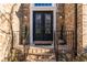 Elegant front door with decorative glass and black metal detailing; brick steps, and manicured potted plants at 271 Double Gate Ct, Sugar Hill, GA 30518