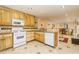 Open kitchen features tile flooring, white appliances, and a view into the dining area at 271 Double Gate Ct, Sugar Hill, GA 30518