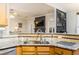 Modern kitchen sink with granite counters and view to the living room at 271 Double Gate Ct, Sugar Hill, GA 30518