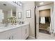 Bathroom with double sink vanity, quartz countertop, modern light fixtures, and a closet at 5885 Waggoner Cv, Rex, GA 30273