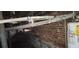 Pipes and water heater in a basement with brick and concrete walls at 1385 Womack Ave, Atlanta, GA 30344