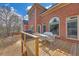Backyard view featuring a two-story brick home and an outdoor deck area with a table, chairs, and a grill at 2740 Heritage Bend Ct, Grayson, GA 30017