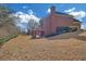 Rear exterior view of brick home features a deck and a spacious, grassy backyard at 2740 Heritage Bend Ct, Grayson, GA 30017