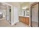 Bathroom with wood vanity, large mirror, tiled floor, and glass enclosed shower, located off bedroom at 2740 Heritage Bend Ct, Grayson, GA 30017