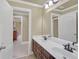 Bathroom featuring double sinks with dark cabinets, white countertops, a mirror, and tile flooring at 2740 Heritage Bend Ct, Grayson, GA 30017