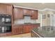Kitchen features wooden cabinets, granite countertops, stainless steel appliances, and tiled backsplash at 2740 Heritage Bend Ct, Grayson, GA 30017