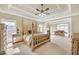 Spacious main bedroom with four-poster bed and tray ceiling and seating area at 2740 Heritage Bend Ct, Grayson, GA 30017
