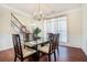 Bright dining room with wood floors, modern chandelier, and glass table with seating for six at 1200 St James Pl, Loganville, GA 30052