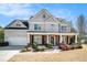 Charming two-story home with a brick-accented front porch and well-manicured landscaping at 1200 St James Pl, Loganville, GA 30052