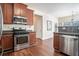 Well-lit kitchen with wood cabinets, stainless steel appliances, and hardwood floors at 1200 St James Pl, Loganville, GA 30052