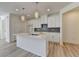 Open kitchen featuring a center island with stone countertops, white cabinets, and modern pendant lighting at 2761 Sandy Rd, Conyers, GA 30013