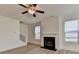 Living room featuring an electric fireplace, a ceiling fan, and natural light from the large windows at 2761 Sandy Rd, Conyers, GA 30013