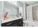 Bright bathroom features a black vanity with white countertop and shower-tub with patterned curtain at 3185 Quinn Pl, Atlanta, GA 30341