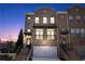 Charming brick townhome with inviting entrance and attached two-car garage at dusk at 3185 Quinn Pl, Atlanta, GA 30341