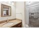 Updated bathroom featuring shower with tiled surround, granite vanity, and framed mirror at 541 Buckingham Cir, Marietta, GA 30066