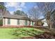 Home's exterior featuring a well-manicured lawn, brick accents, and mature trees creating a peaceful setting at 541 Buckingham Cir, Marietta, GA 30066