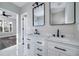 This modern bathroom features double sinks with black hardware and marble counter tops at 944 Woodland Se Ave, Atlanta, GA 30316