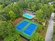 Overhead view of two blue tennis courts alongside a blue pool and clubhouse area surrounded by vibrant greenery at 1430 Watercove Ln, Lawrenceville, GA 30043