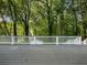 Large back deck with white railing surrounded by lush trees at 1430 Watercove Ln, Lawrenceville, GA 30043