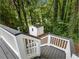 View of a backyard with a white storage shed, surrounded by lush greenery and a deck with gray stairs at 1430 Watercove Ln, Lawrenceville, GA 30043