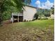 Spacious backyard featuring a lush lawn, mature trees, a wooden deck and ample space for outdoor activities at 1430 Watercove Ln, Lawrenceville, GA 30043