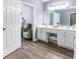 Bright bathroom with double sinks, white cabinets and drawers, with an open doorway to bedroom sitting area at 1430 Watercove Ln, Lawrenceville, GA 30043