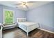 Well-lit bedroom with a full bed, bench seat, blue walls, and a large picture window at 1430 Watercove Ln, Lawrenceville, GA 30043