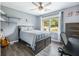Cozy bedroom with wood-look floors, window with natural light, desk, and a dark wood dresser at 1430 Watercove Ln, Lawrenceville, GA 30043